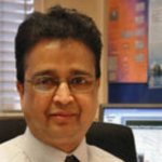 Close up profile of a man wearing glasses, shirt and a tie